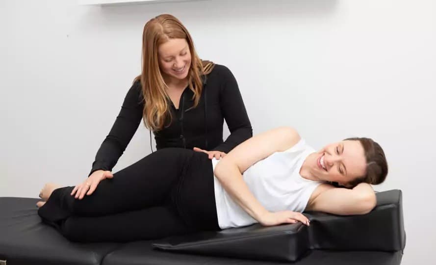 A therapist working hands-on with a client on a treatment table in the Wellness Suite